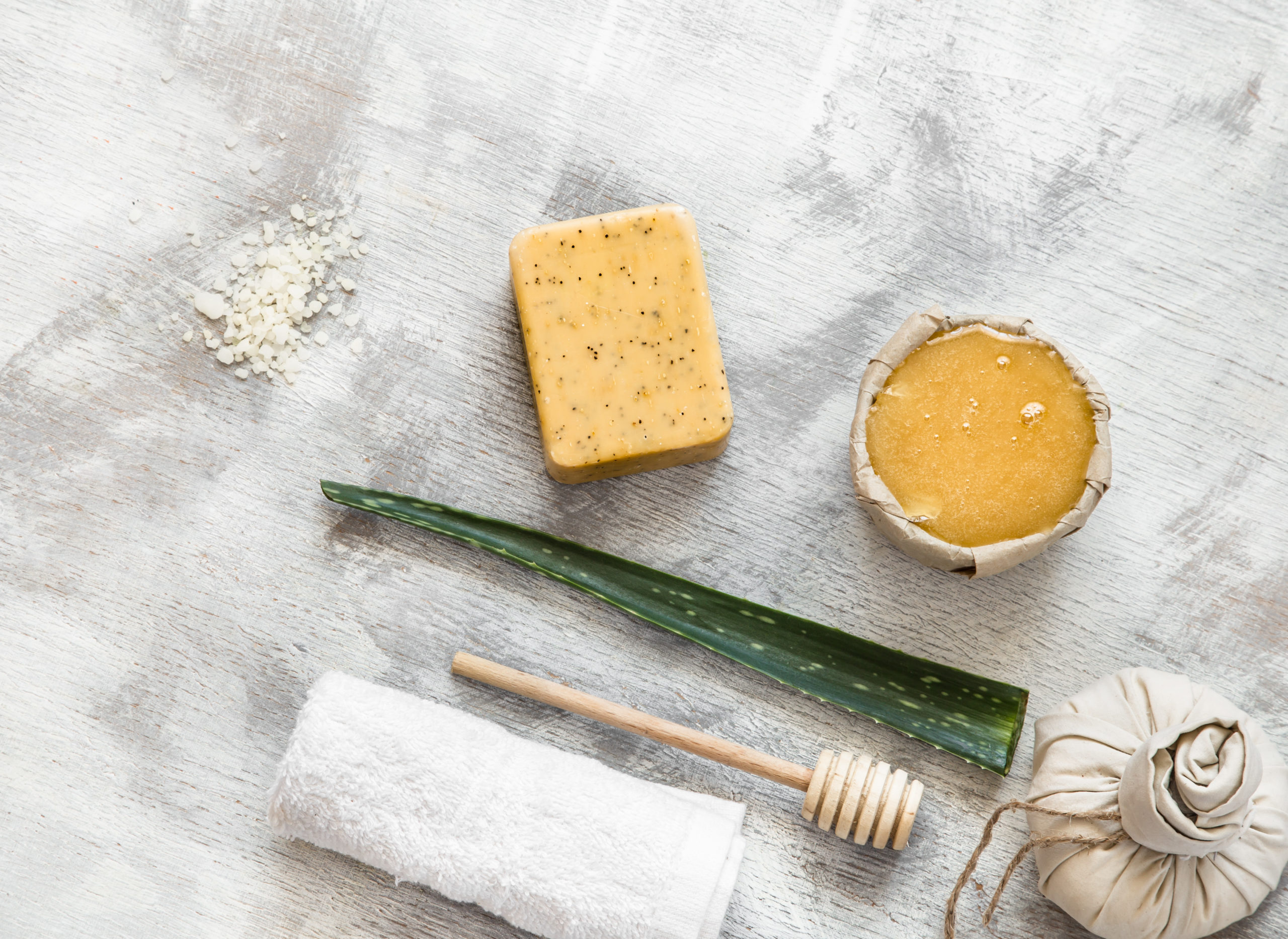 Natural beautiful Spa cosmetics for body care, on a light wooden background. Honey and soap with items to cleanse the skin. The concept of health and body care .