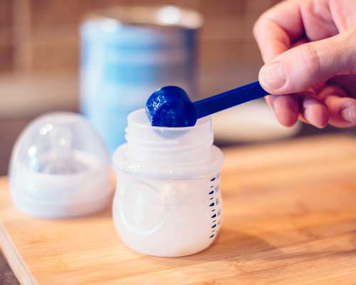 father-making-baby-formula-in-milk-bottle-2021-08-26-23-02-51-utc